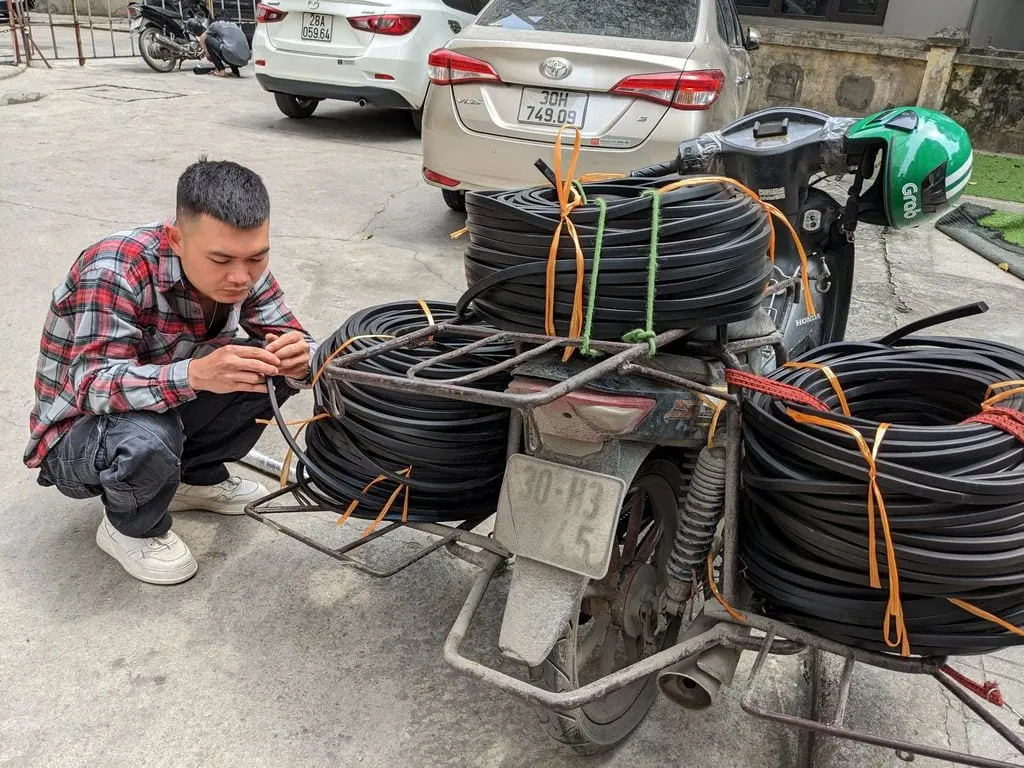 Người buộc cuộn dây lên xe máy trước khi giao