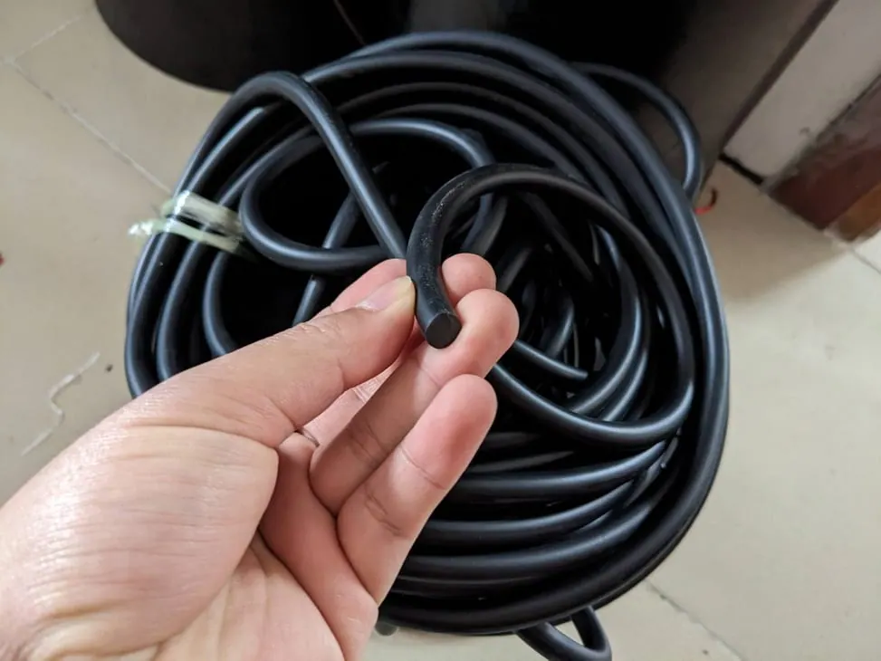 Tay cầm đoạn dây trước cuộn dây trên nền gạch