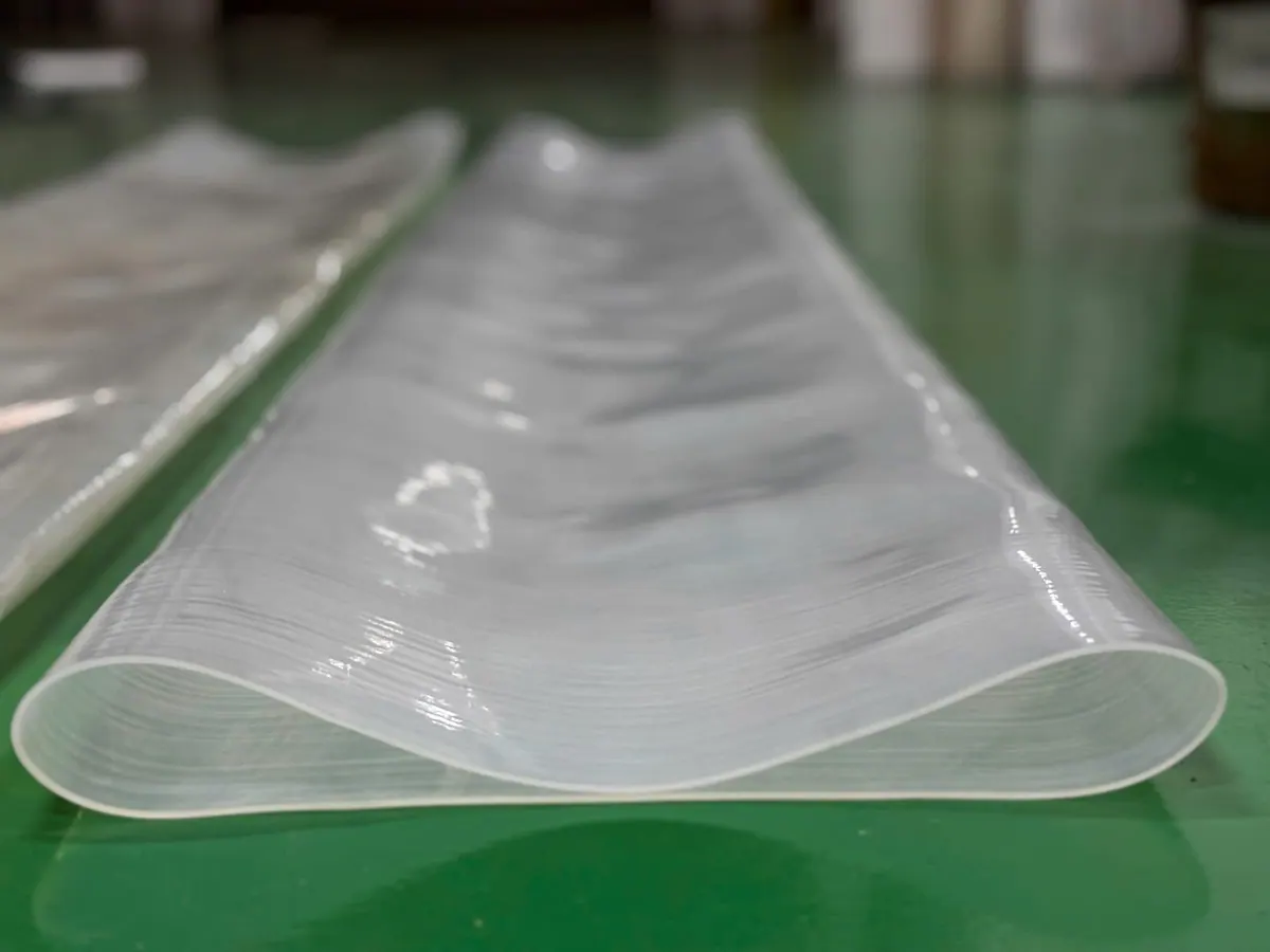 Ống silicone bản dẹt trải trên bàn xanh, góc chụp khác