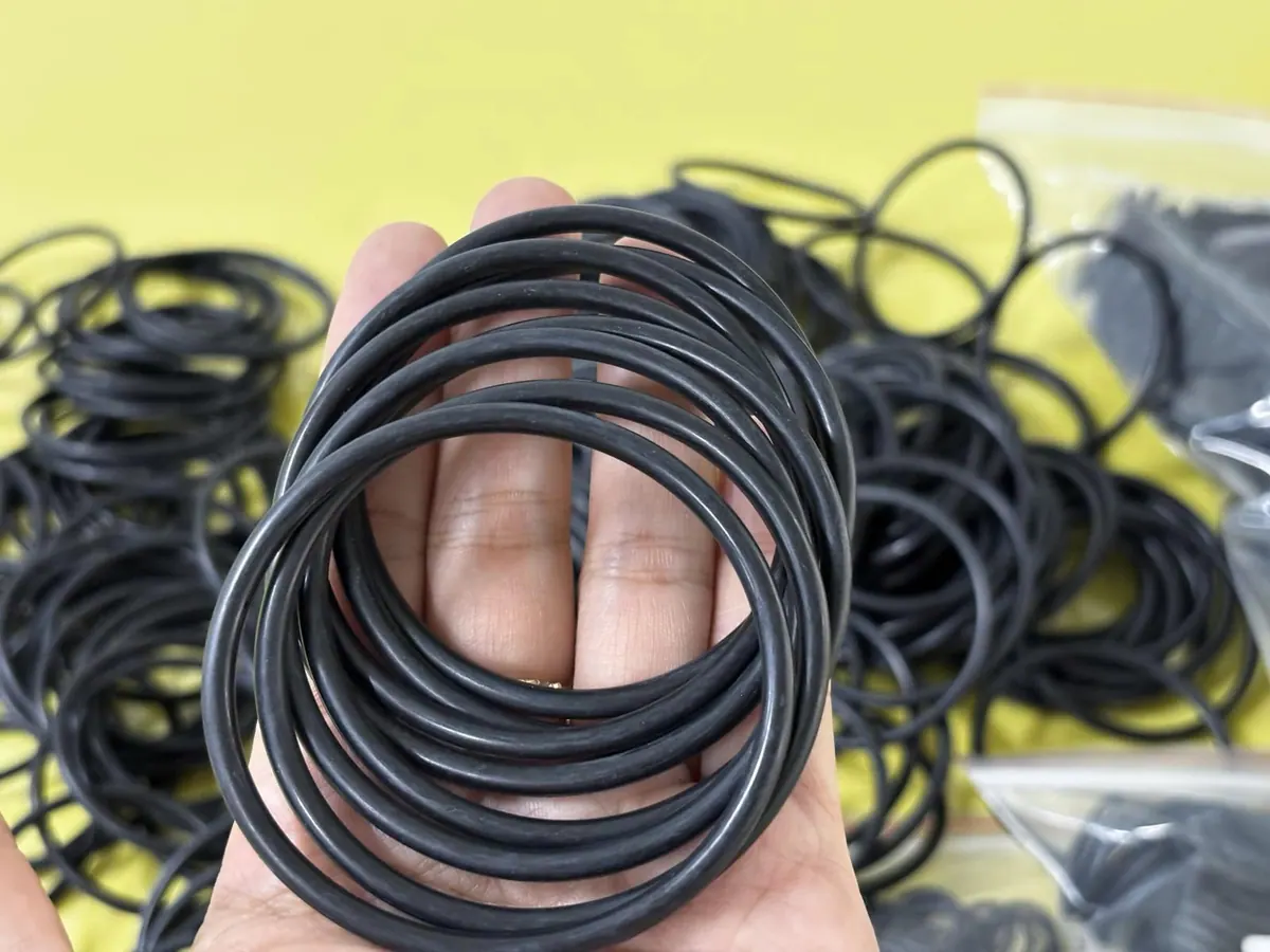 Gioăng oring tròn NBR màu đen chịu dầu, một bó nhiều cỡ trên lòng bàn tay