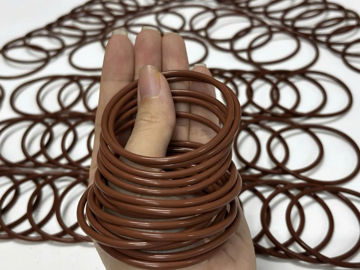 Tay bới chồng oring nâu trên bàn trắng