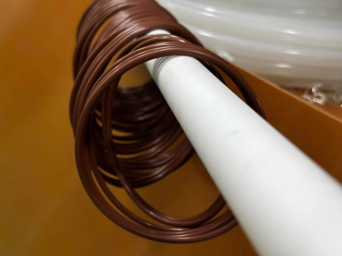 Chồng oring nâu luồn qua ống nhựa trắng