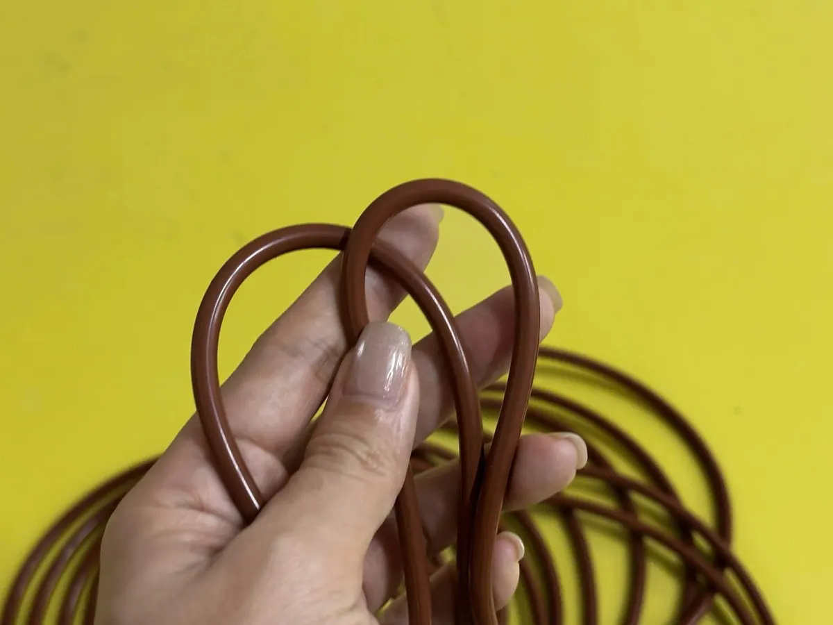 Tay giữ vòng oring nâu trên bàn vàng