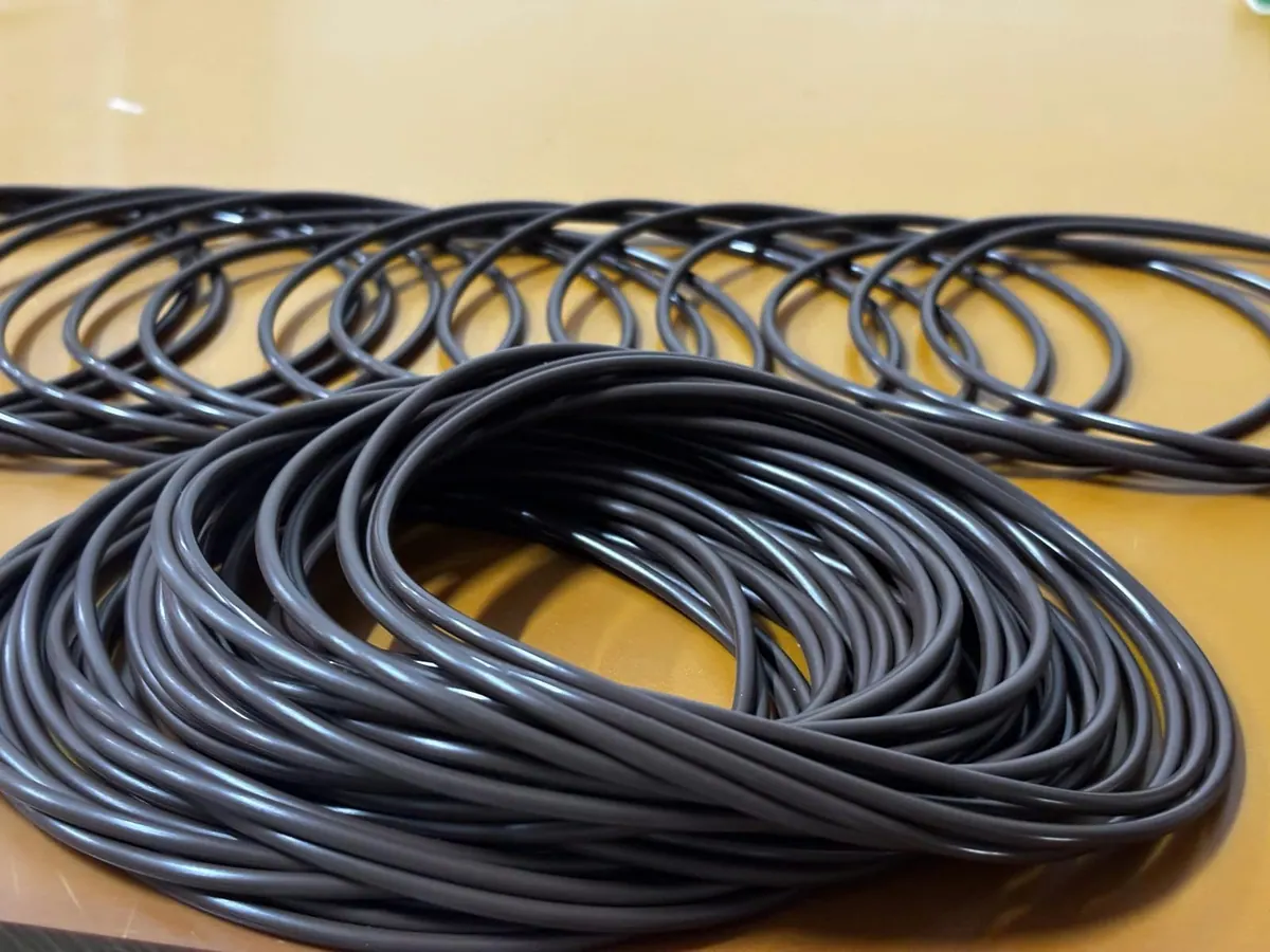 Oring màu đen dây mảnh trải thành dải trên bàn vàng