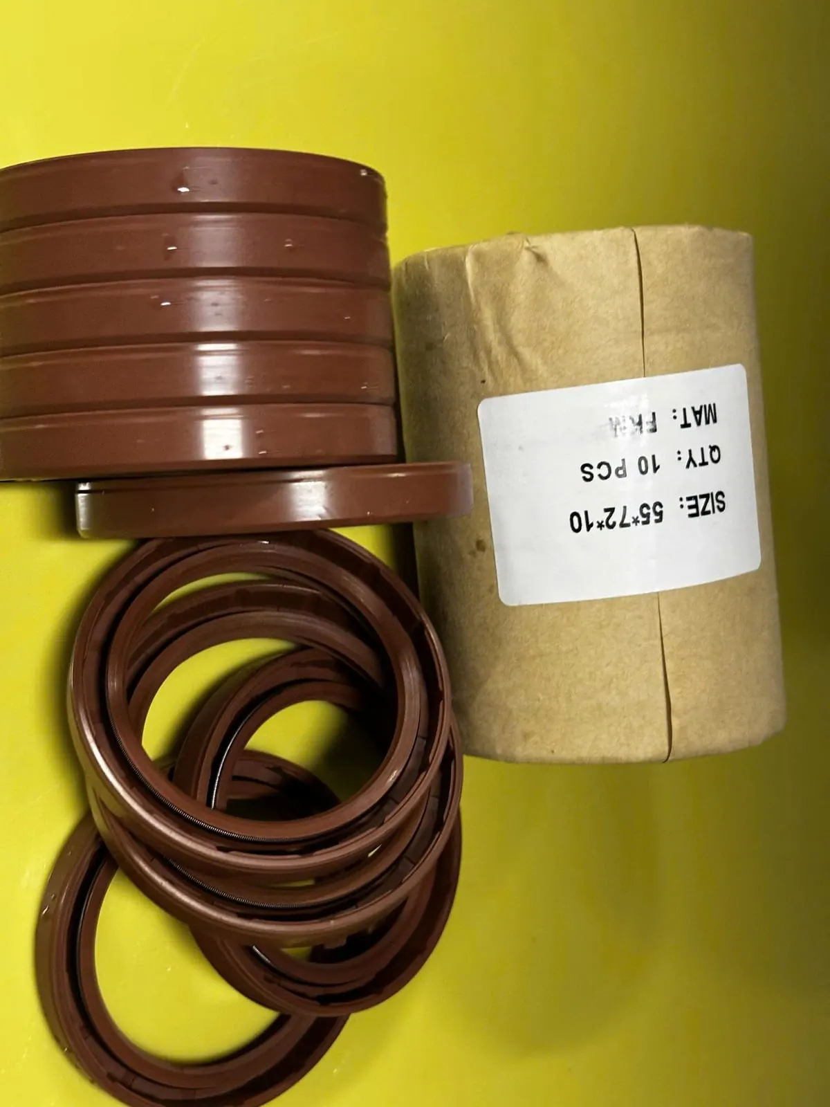 Chồng phớt Viton xếp cạnh cuộn giấy trên bàn vàng