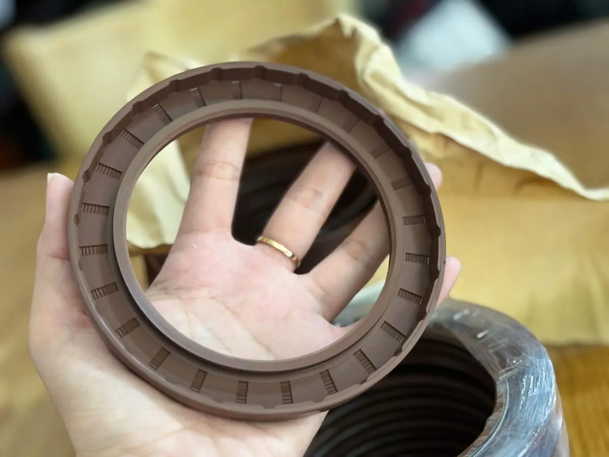 Tay luồn ngón qua chiếc phớt Viton cạnh giấy gói